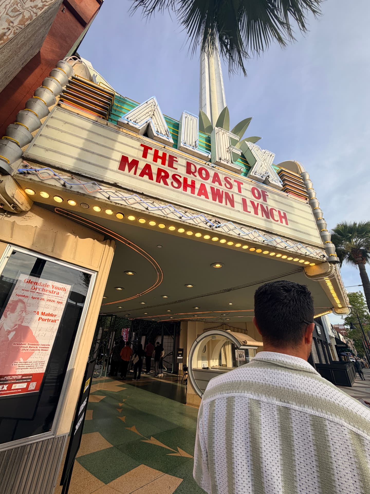 Theatre marquee on a palm-lined street at golden hour